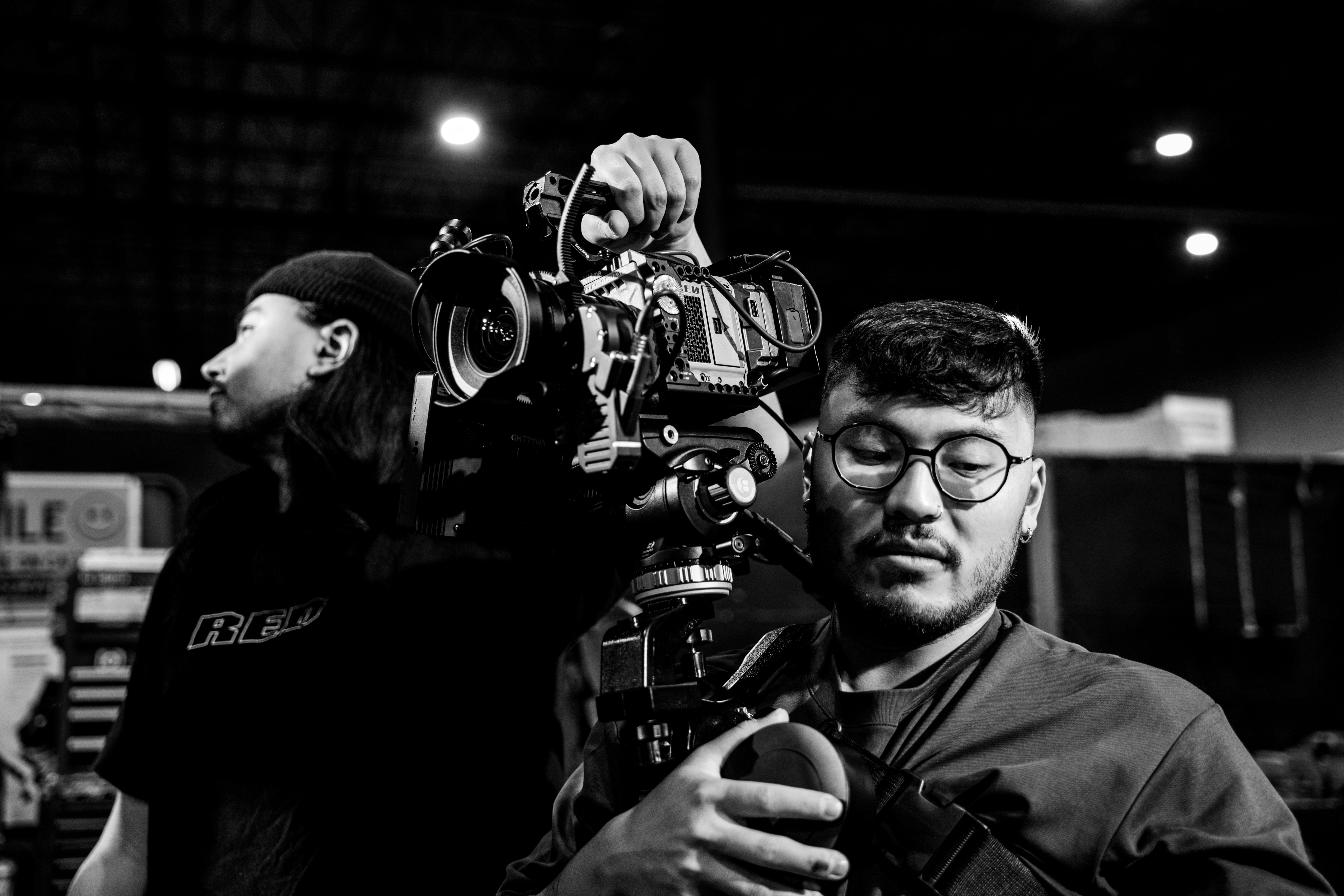 a black and white photo of a man holding a camera